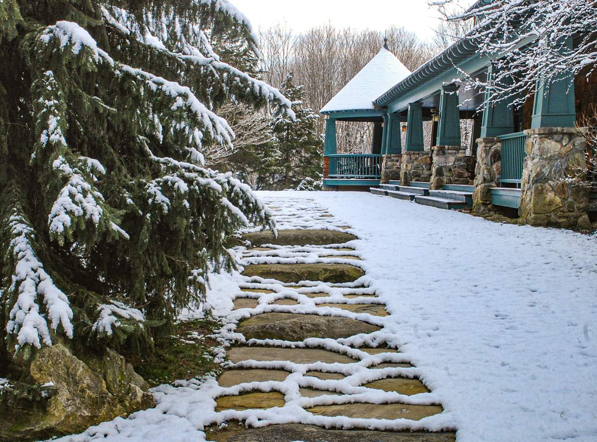 Snow outlining the irregular stones of the walkway beside the porch and its new steps