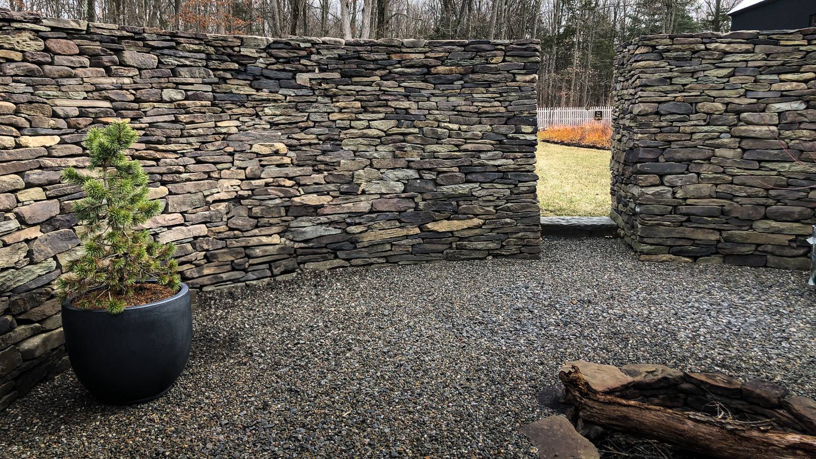 Gravel interior of the stone ruin with a potted pine