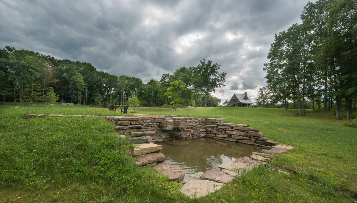 Spring pool with the house on the hillside beyond