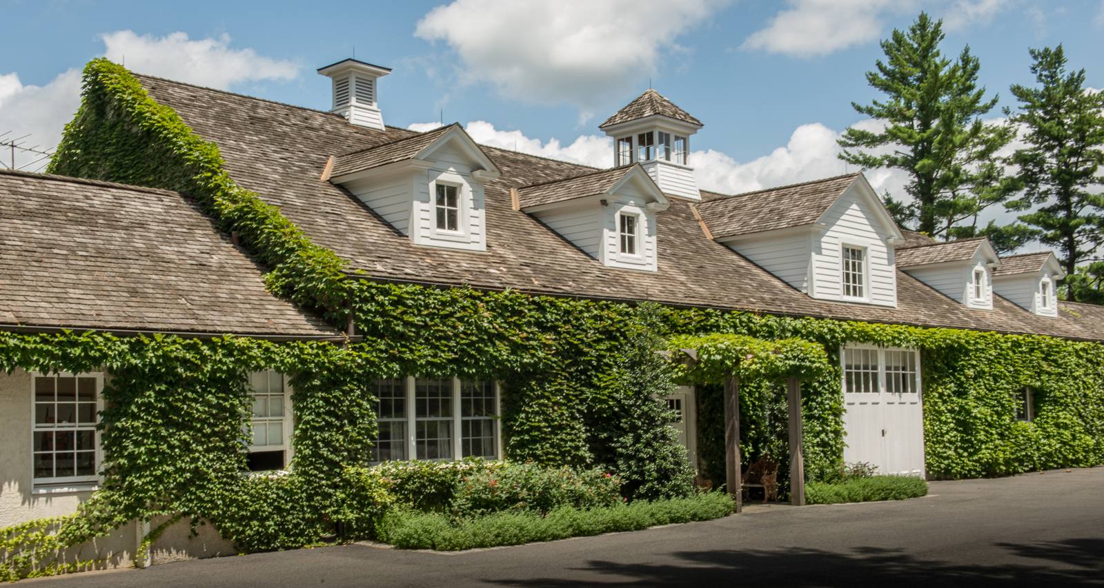 Ivy-covered building with cupolas and a vine-covered pergola