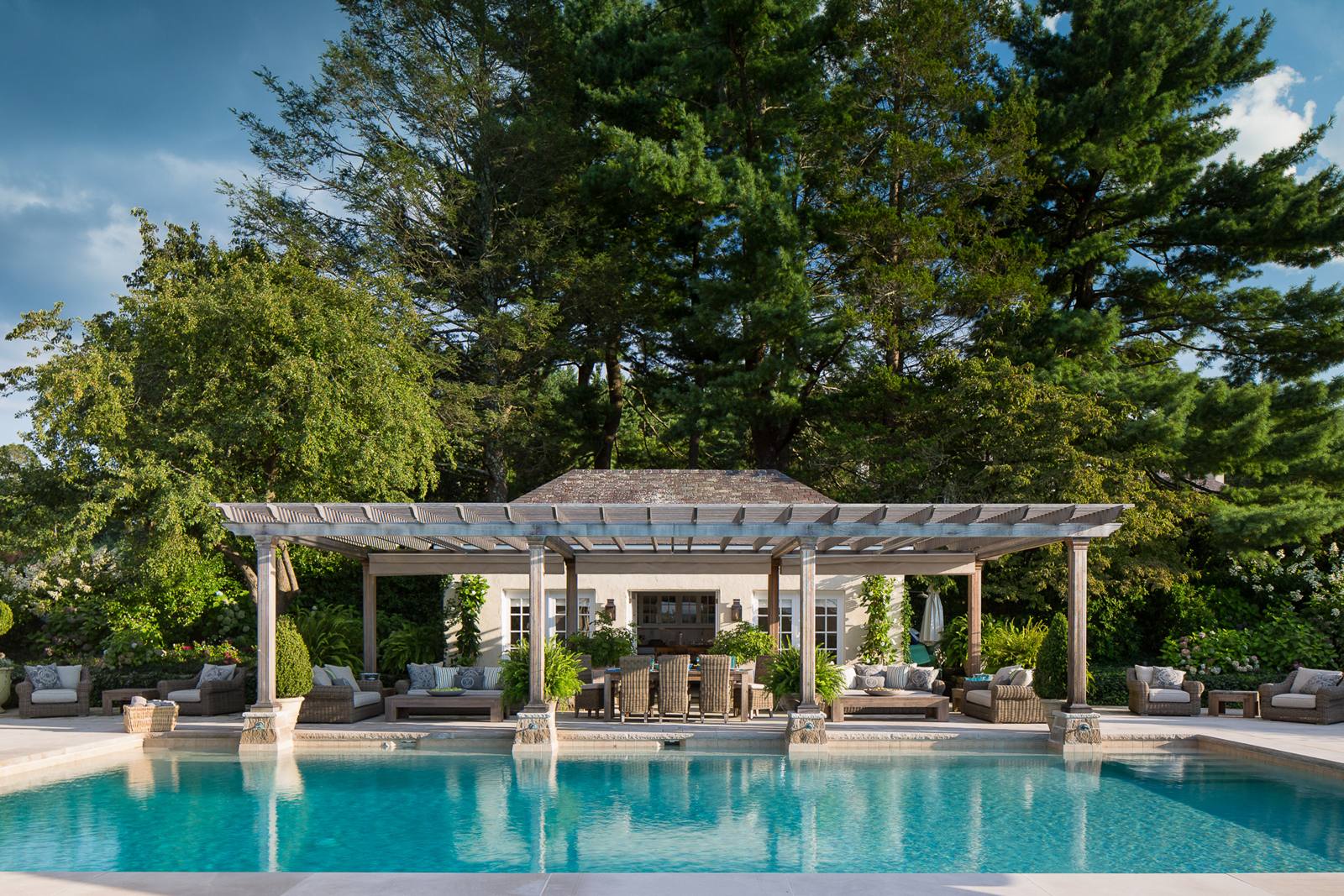 Swimming pool with a wooden pergola and pool house