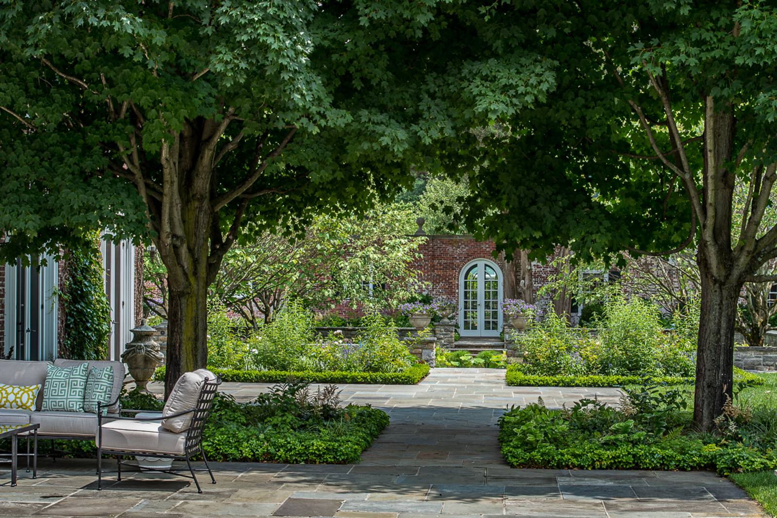 Bluestone path through maples to an arched door