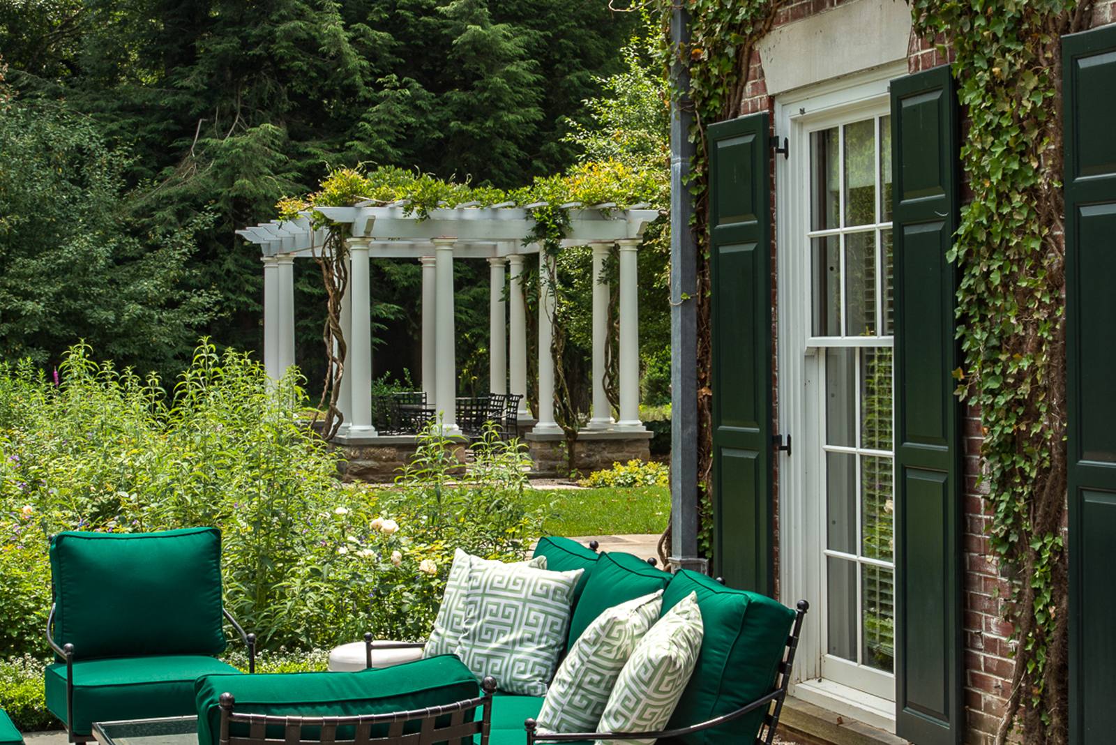 Pergola framed by wisteria and perennials