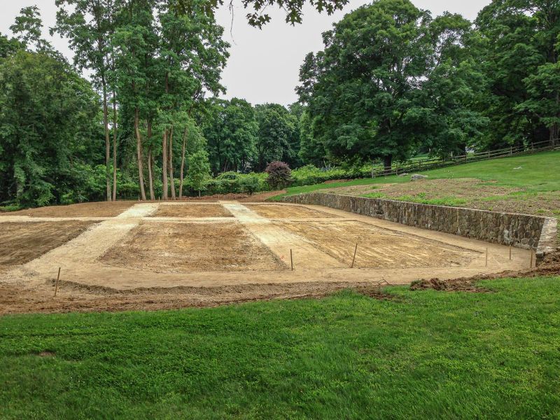 Graded beds and paths laid out below the stone retaining wall
