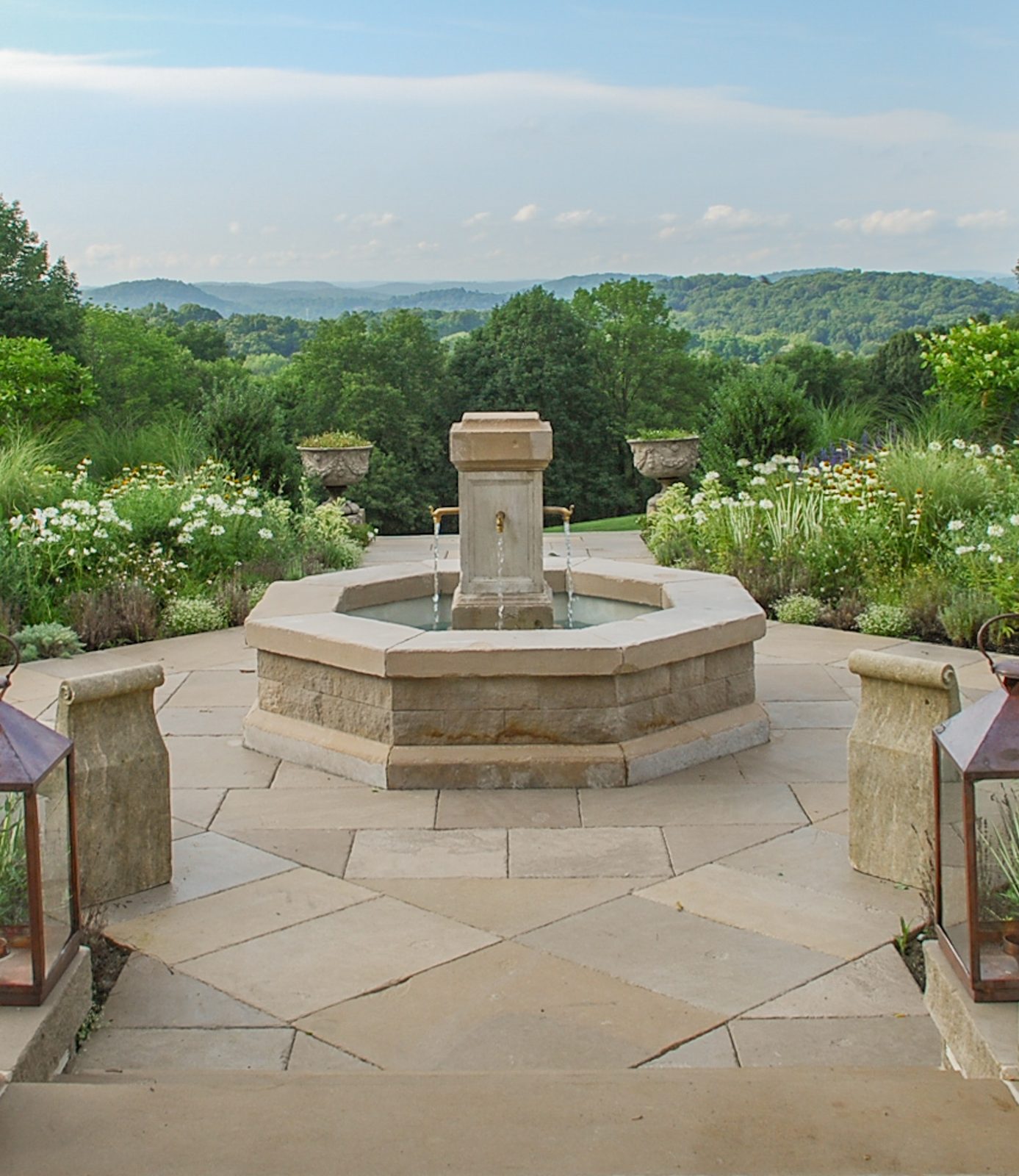 Octagonal terrace fountain with brass spouts overlooking rolling hills